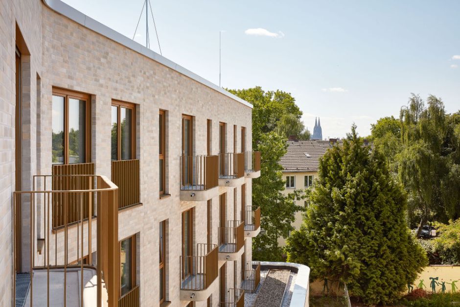 Blick von einem Balkon des Haus Adelheid. In der linken Bildhälfte ist das Haus Adelheid zu sehen, rechts die Grünanlage und ein Nachbarhaus. In der Ferne ist der Kölner Dom sichtbar.