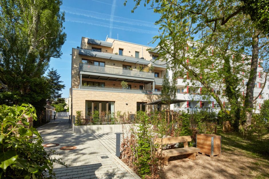 Mehrstöckiges Mehrfamilienhaus Ansicht vom Garten auf die Balkone und Terrassen