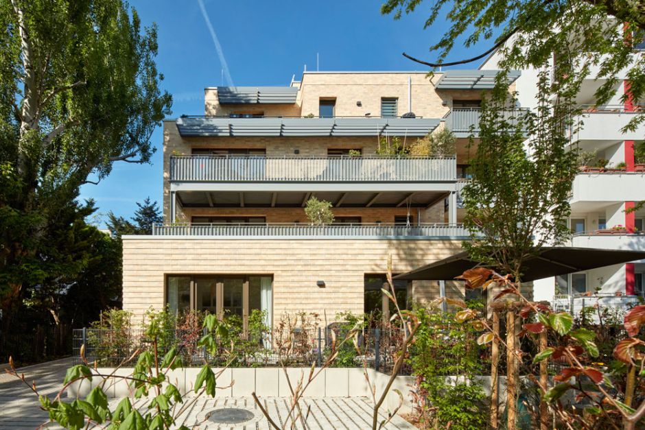 Mehrstöckiges Mehrfamilienhaus Ansicht vom Garten auf die Balkone und Terrassen